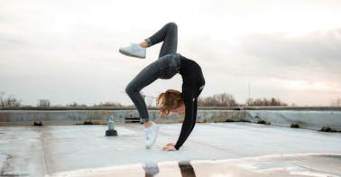 Woman doing backward flip representing dynamic learning and development and skills.