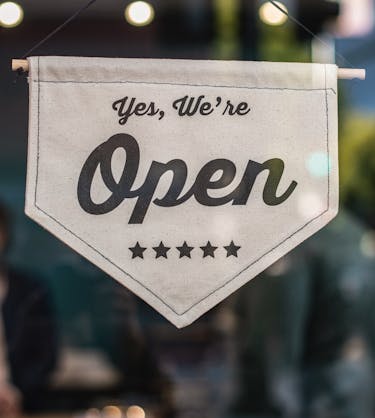 An open sign representing customer education 